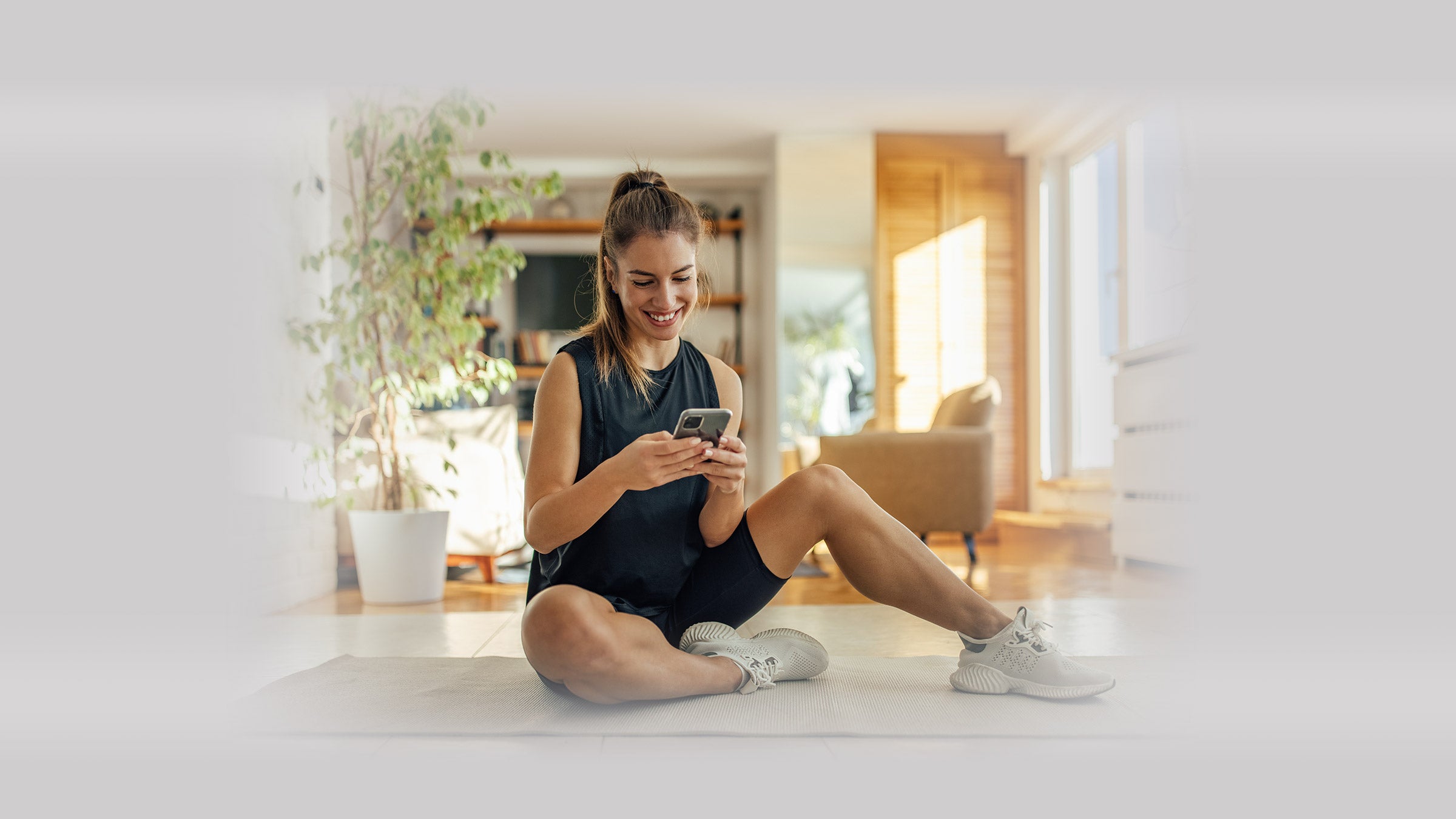 Woman sitting on the floor in a house scrolling on her phone