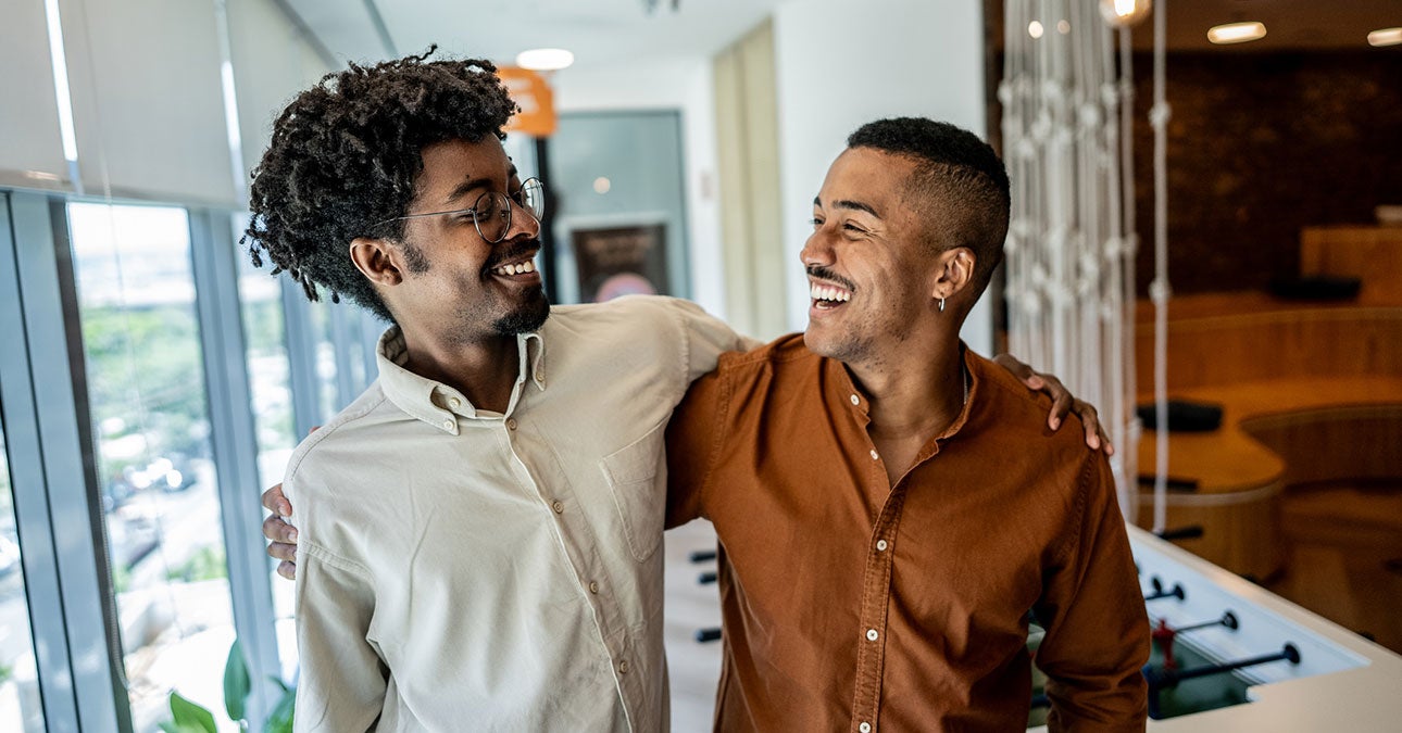 Two men smiling and hugging