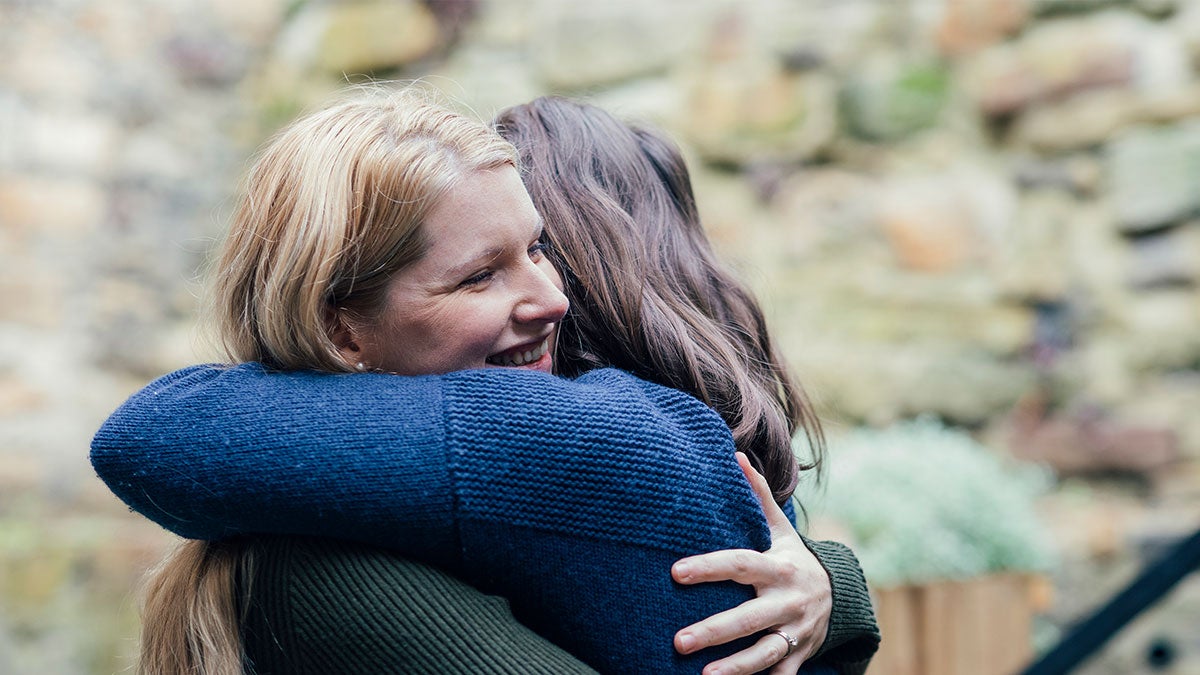 Two ladies hugging each other