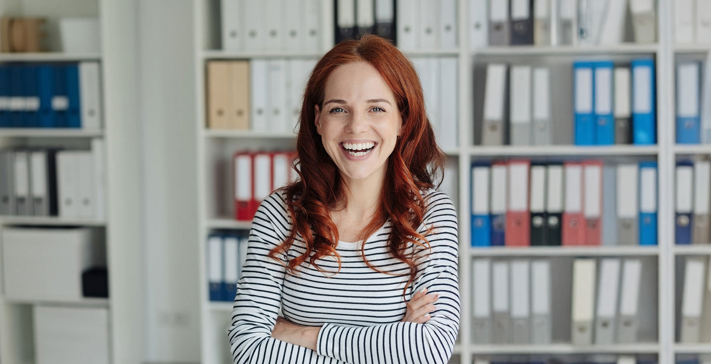 A woman smiling with her arms crossed