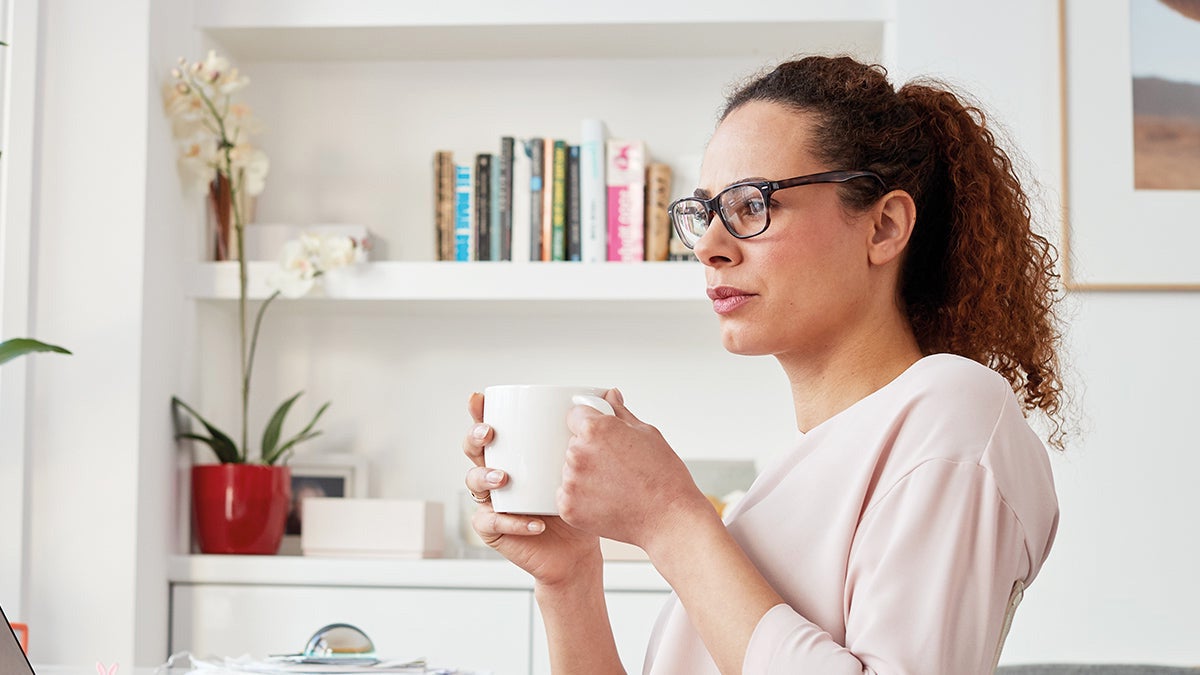 Woman drinking coffee in deep thought