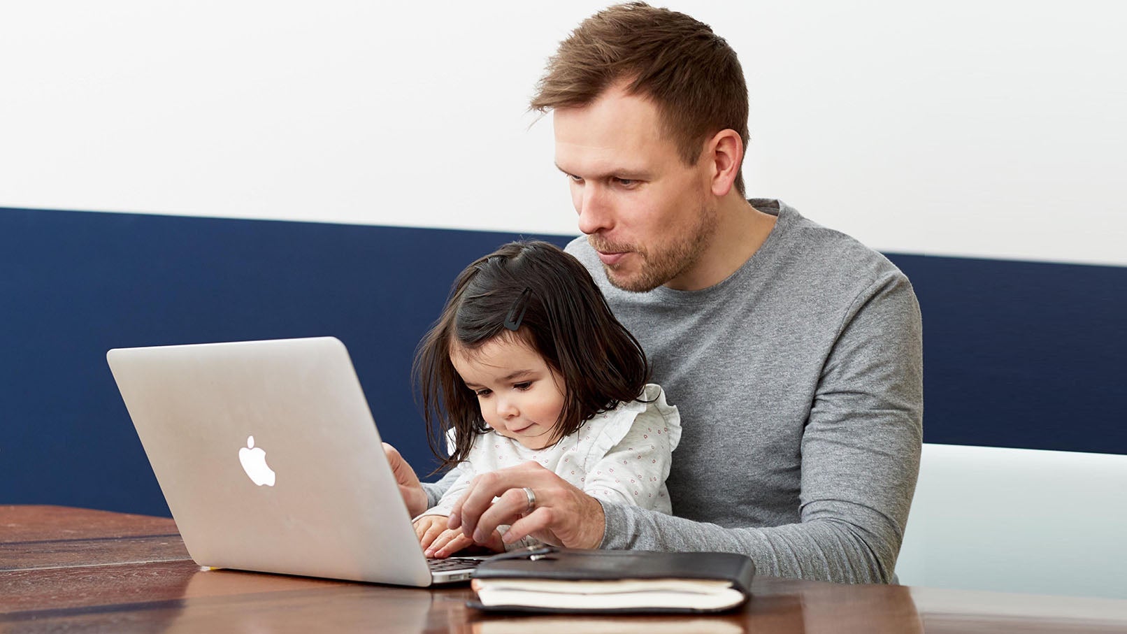 Man with child typing on laptop