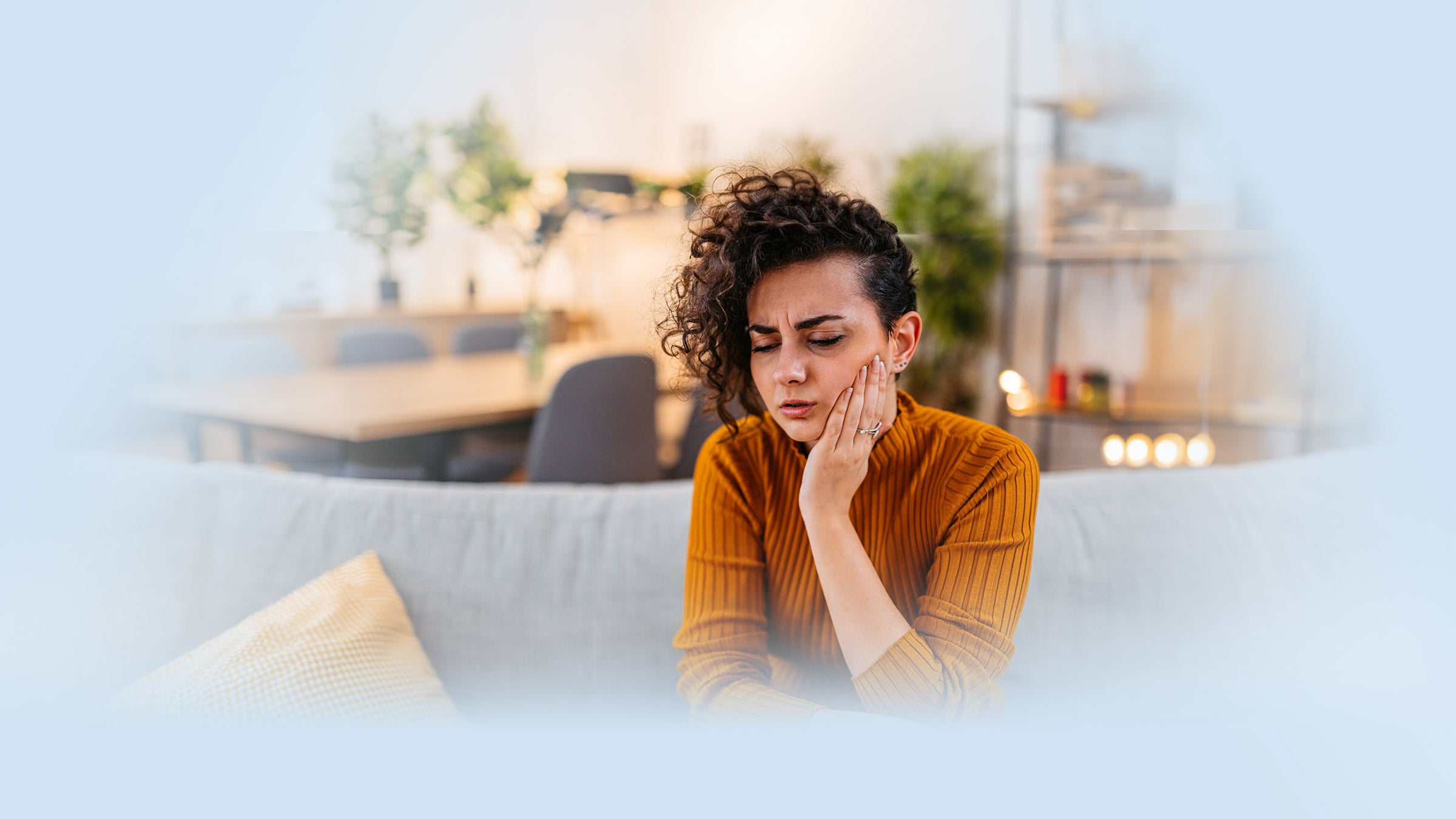 A woman having a tooth ache, pressing hand to her cheek