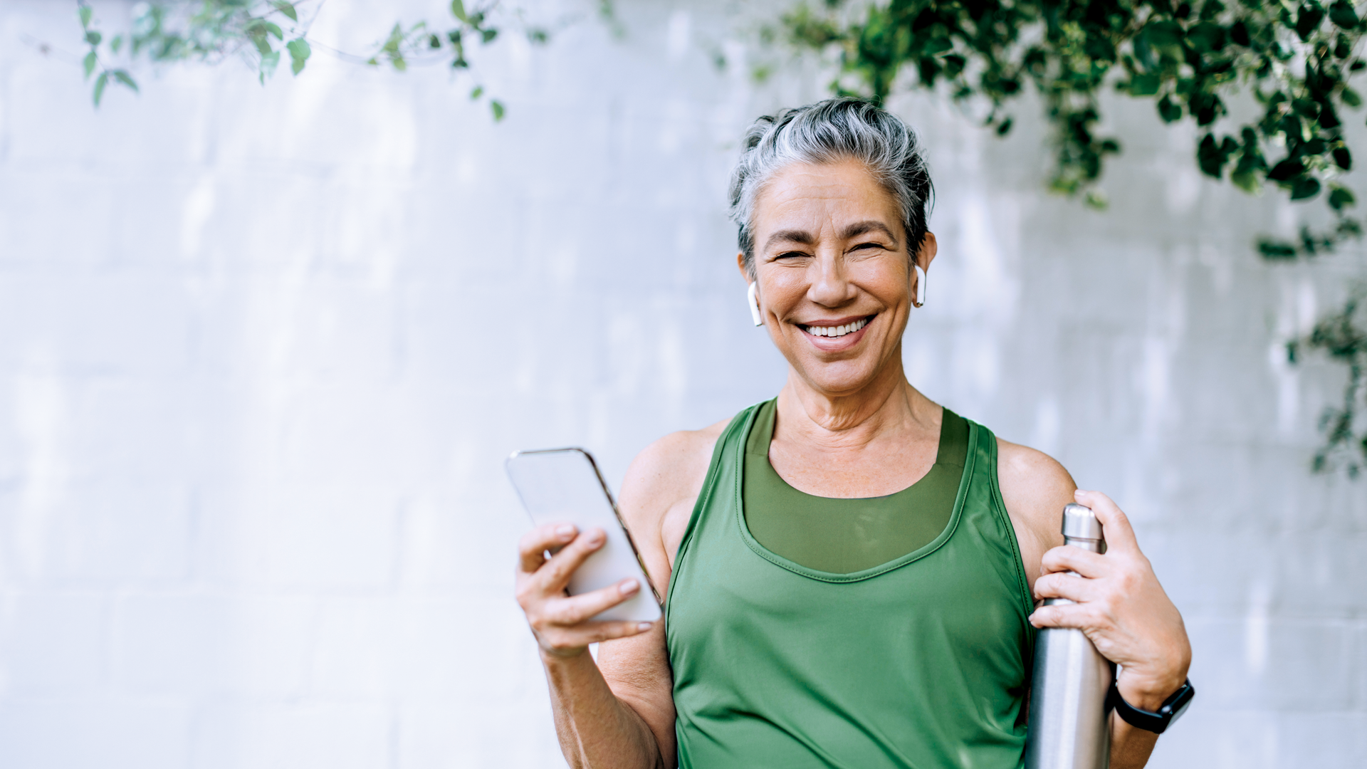 A woman holding a phone and smiling