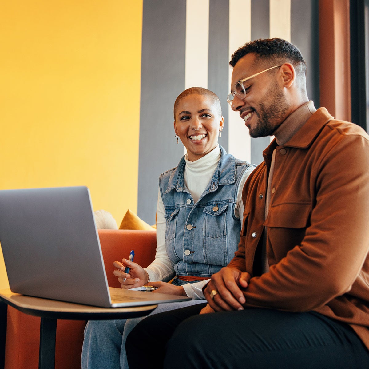 Man and woman looking at the laptop smiling