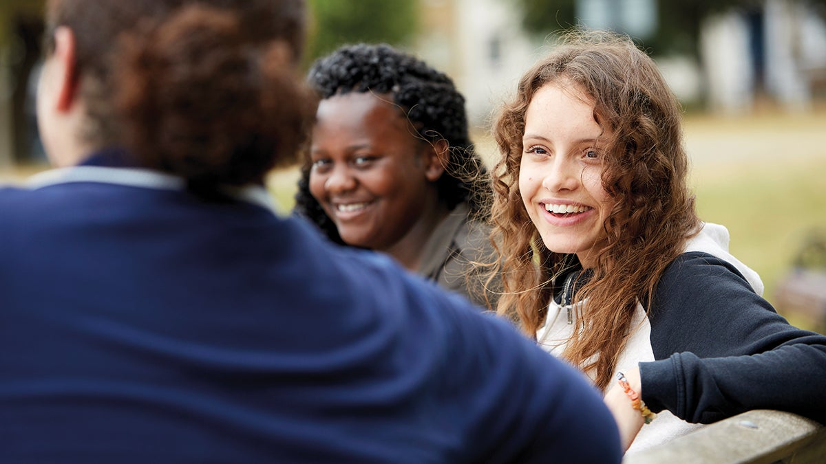 Young people sitting outdoors and smiling