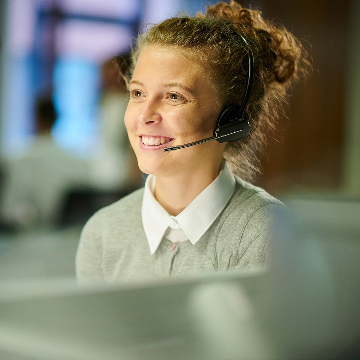 A woman with a head set smiling 