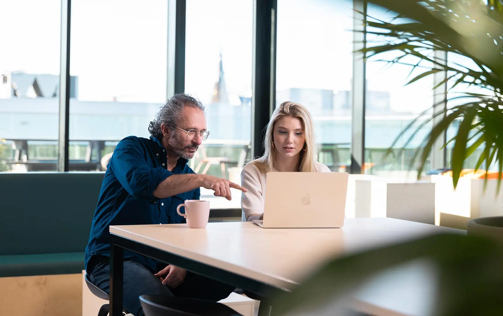 Student en docent van Master AI translator zitten samen achter een laptop