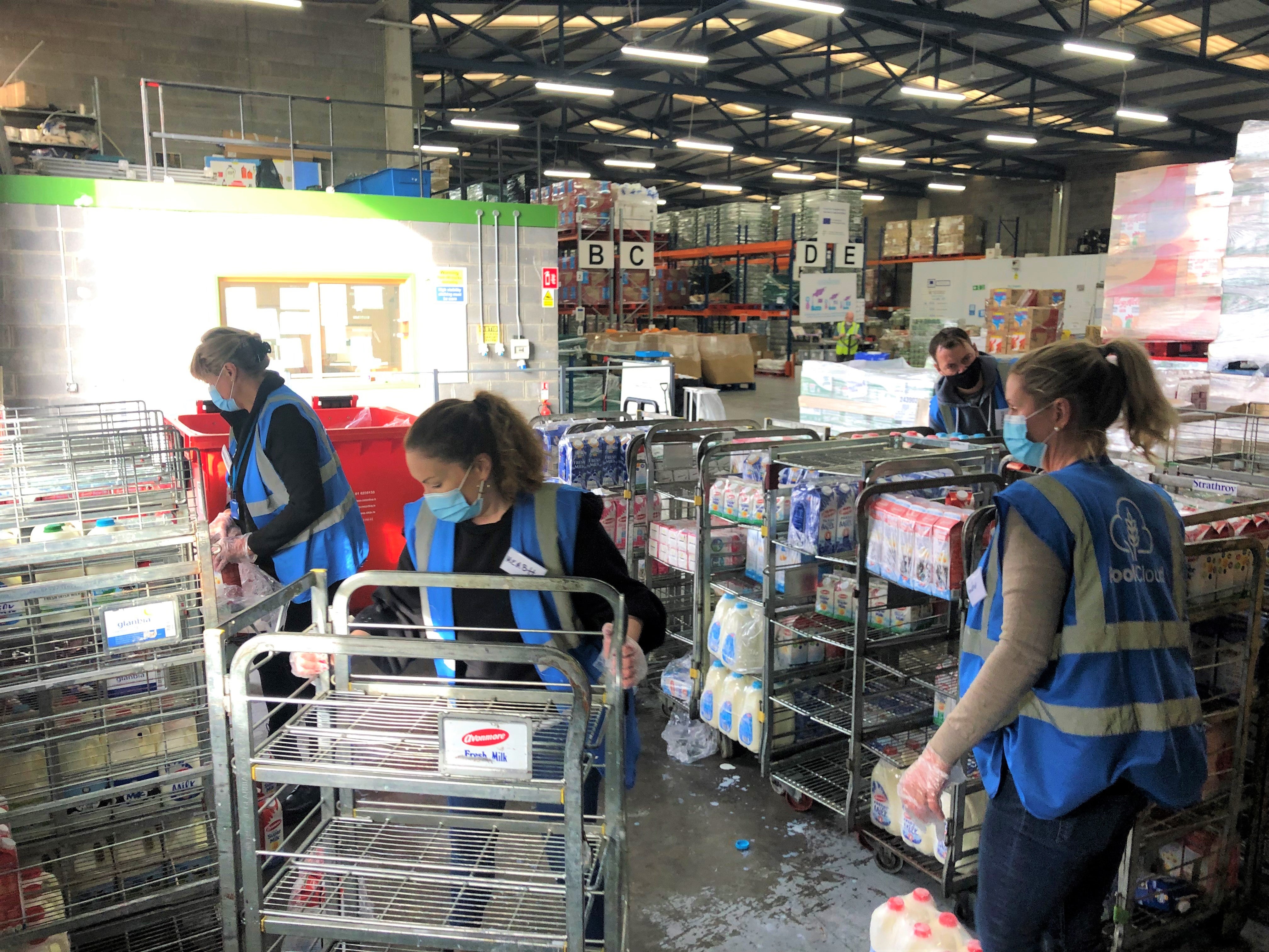 Team of volunteers sorting out milk in a warehouse