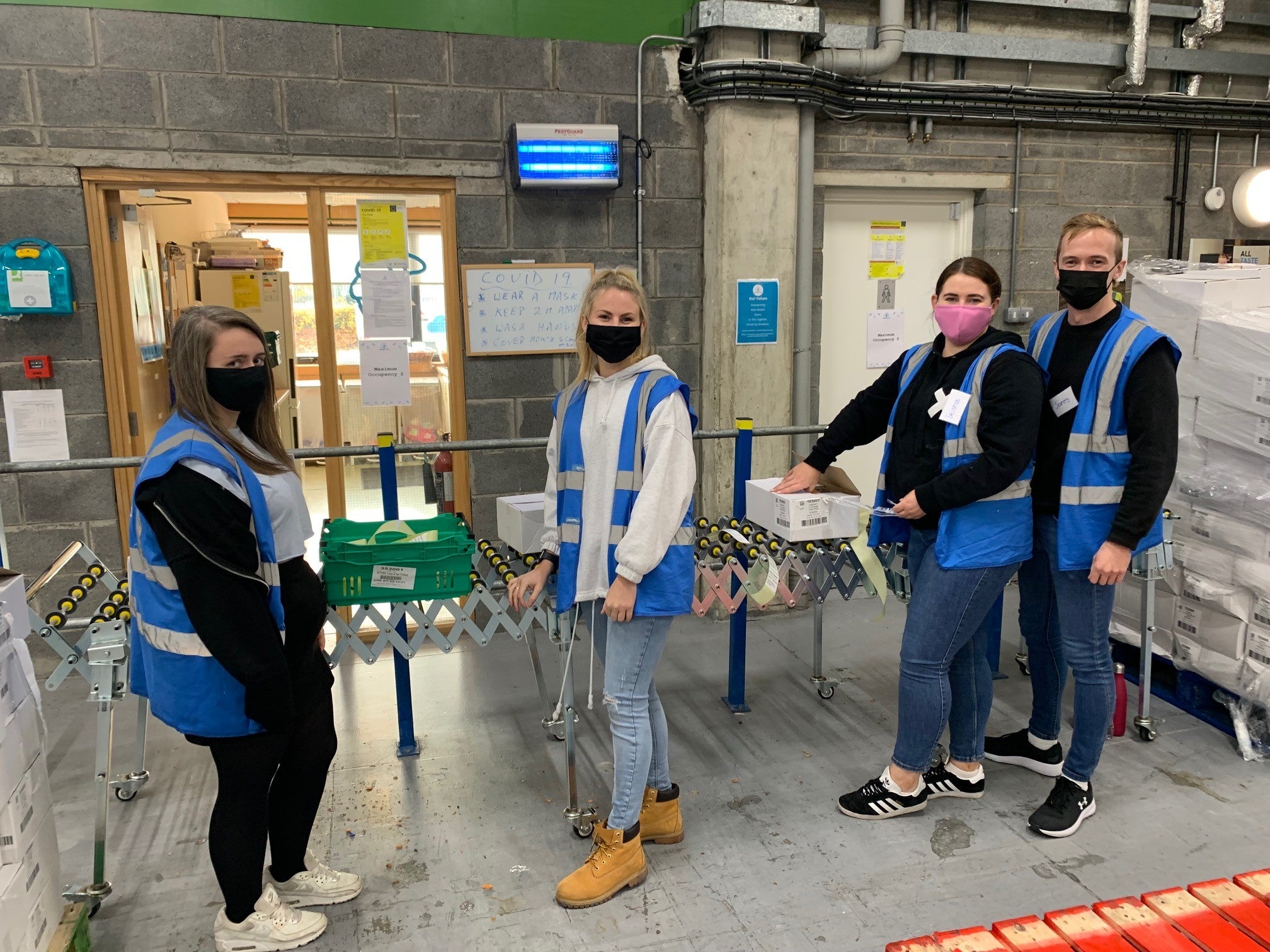 Team of volunteers relabeling produce in a warehouse 