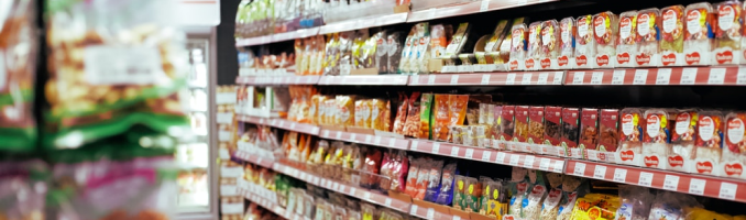 Food aisle in supermarket with full shelves of produce