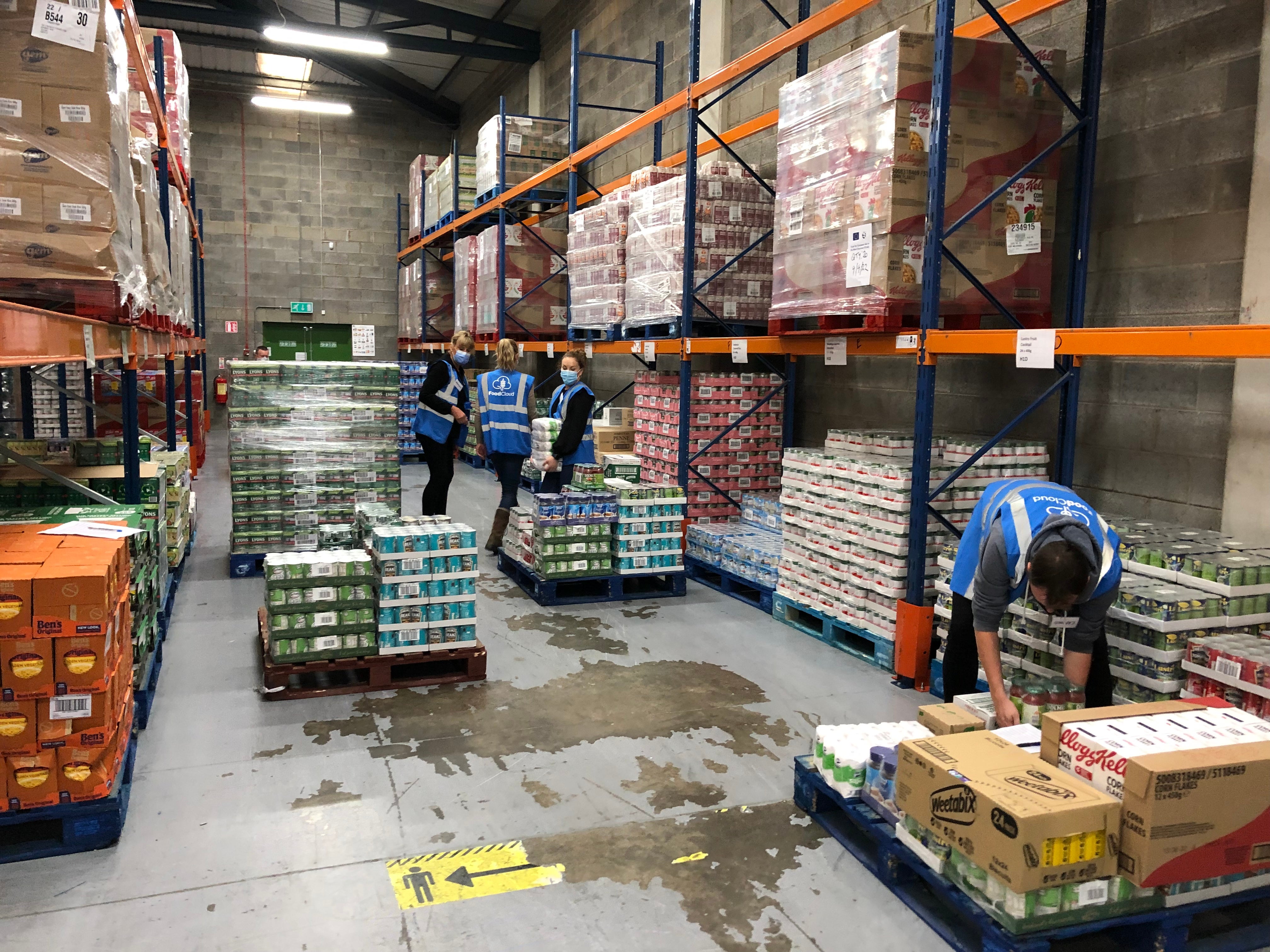 Team-of-volunteers-stacking-food-products-on-to-crates-in-warehouse