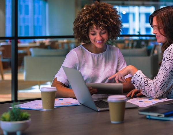 Two people looking at notes on a desk