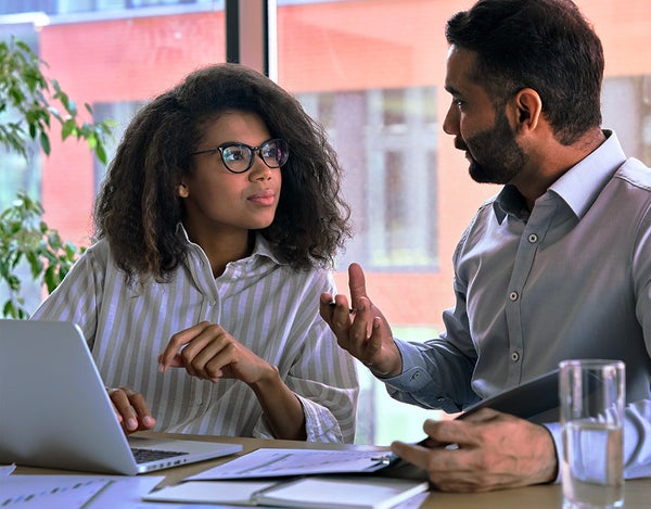2 people sat at a desk in discussion