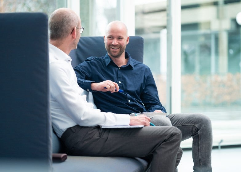 Twee collega's in gesprek op kantoor