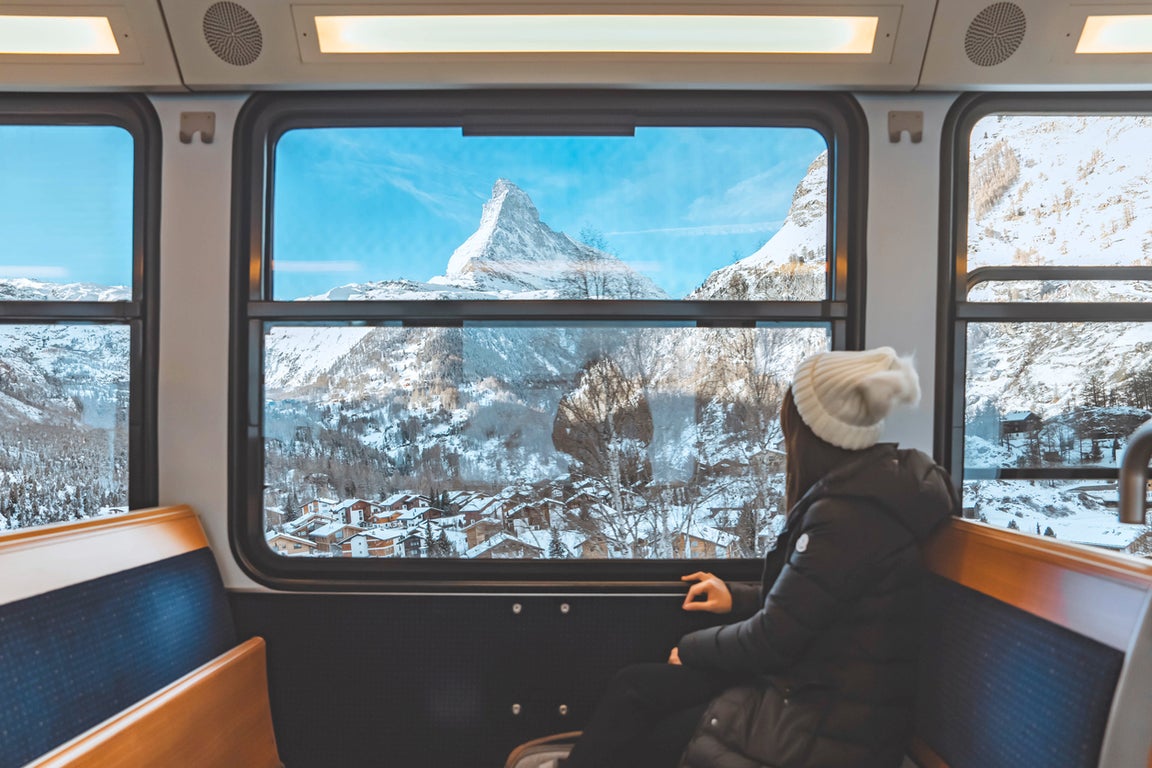 Tourist looks out the window at the Matterhorn mountain from a train near Zermatt, Switzerland