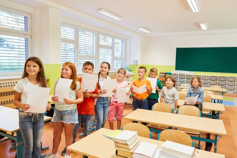 Kinder warten freudig mit einem Blatt in der Hand (Foto: Shutterstock)