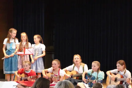 Schülerinnen der GS Lajen singen und musizieren mit Referentin Johanna Mader beim Abschluss des Projektes Musigkischtl im Mai 2024.