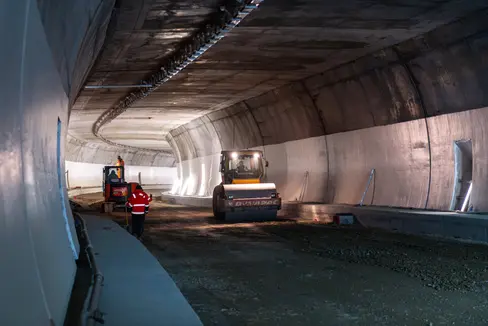 Si lavora alacremente alla costruzione della circonvallazione nord-ovest di Merano, affinché la galleria possa essere aperta al traffico nel tardo autunno del 2026. Nel dicembre 2025 è stato completato il rivestimento della galleria nel tratto compreso tra il portale di Monte San Zeno e la rotatoria sotterranea ed è stato applicato un primo strato di asfalto. (Foto: USP/Carron Bau)