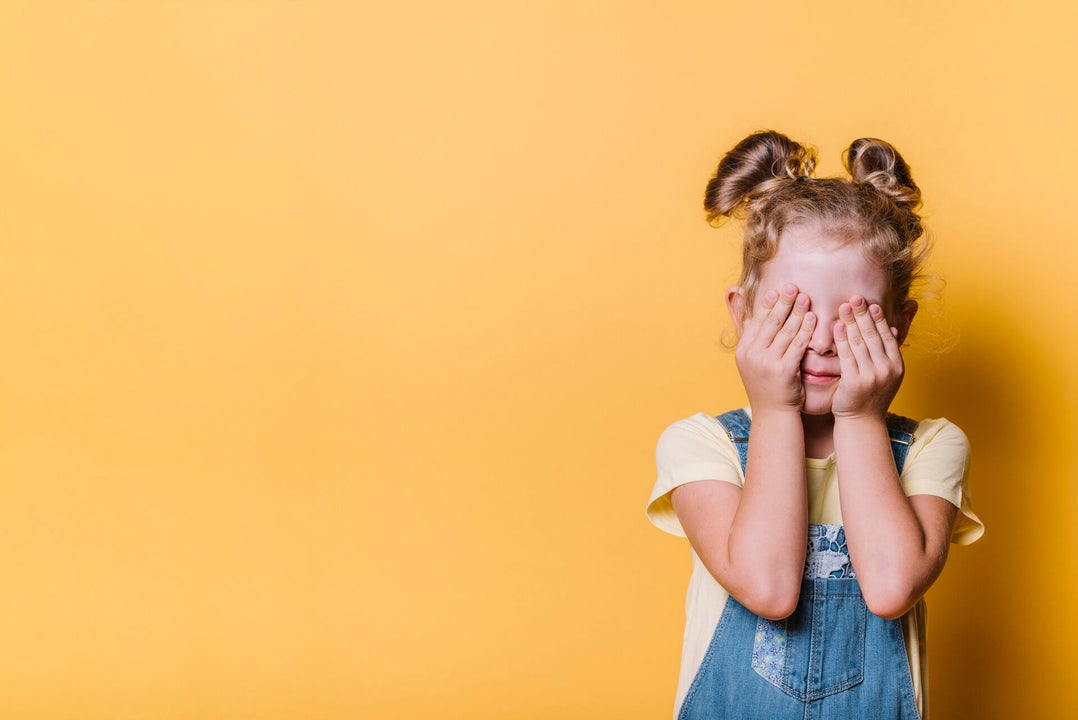 Meisje met haar handen voor haar ogen