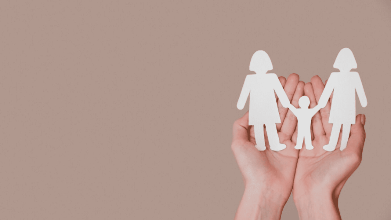 Een persoon die een papieren knipsel van een vrouw en kind vasthoudt