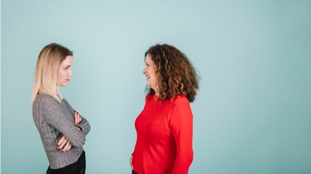 Moeder en dochter in gesprek, dochter heeft enigszins defensieve houding