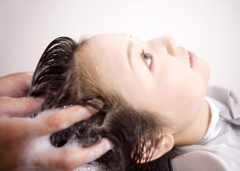 Haren wassen bij kapper