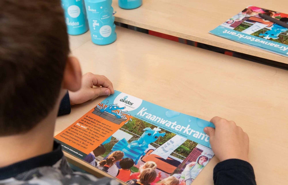 Kind houdt Evides Kraanwaterkrant vast