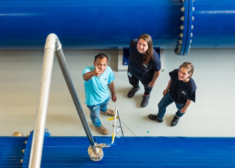 Collega wijst iets aan bovenop een machine in de fabriek