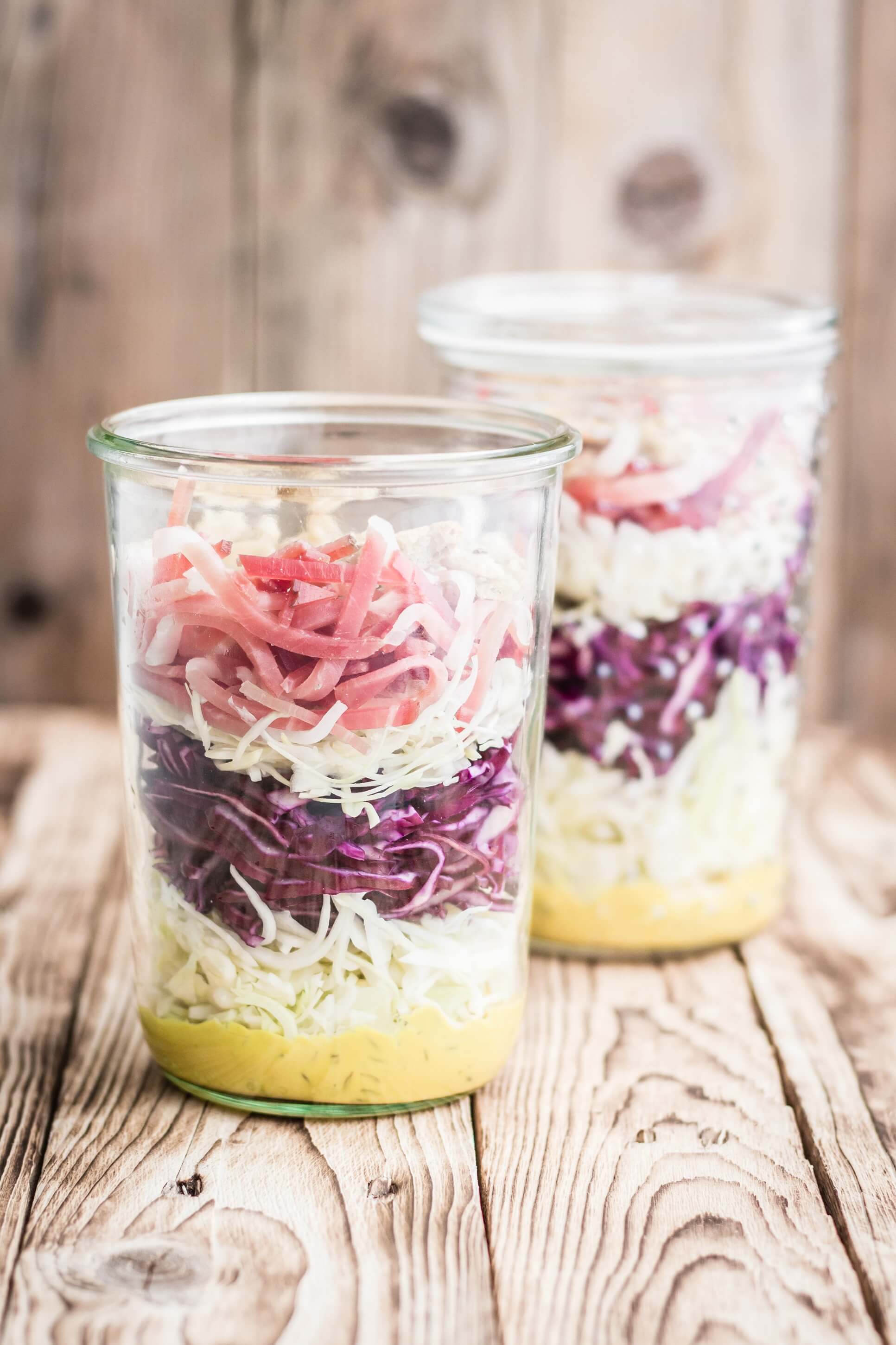 Krautsalat mit weißem und rotem Kohl sowie Südtiroler Speck g.g.A., in Streichholzstreifen geschnitten.