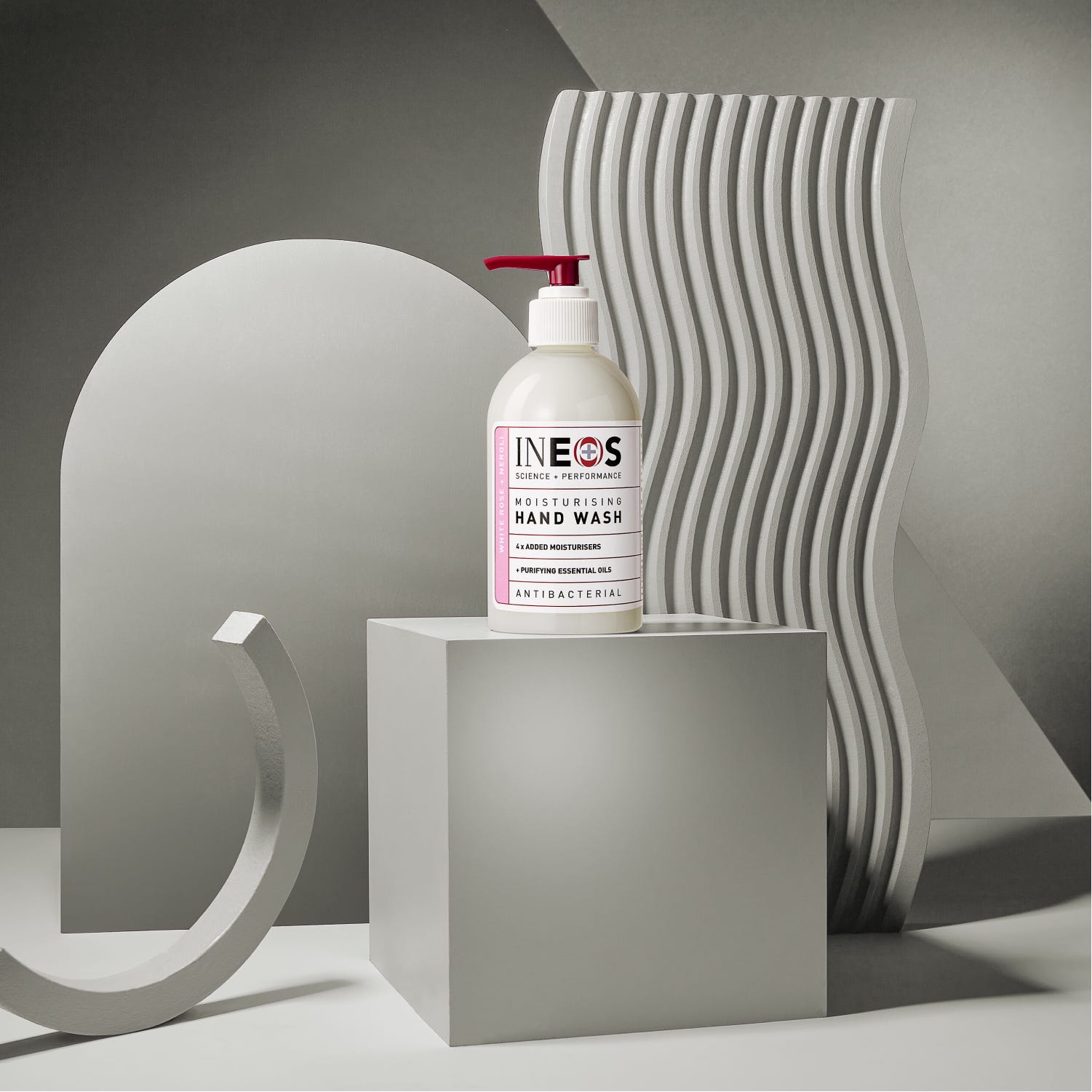 a photo of ineos hygienics moisturising white rose and neroli hand wash on an abstract grey background
