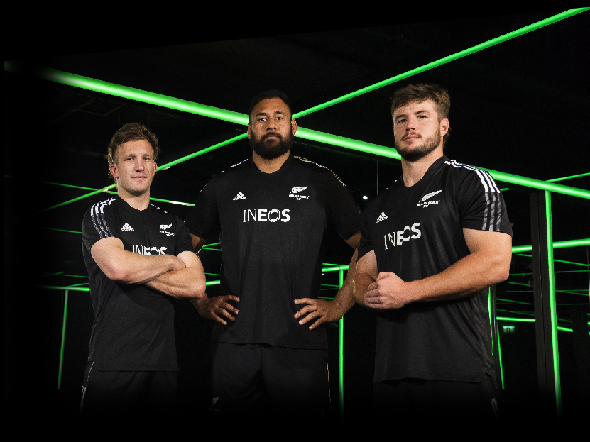Three All Blacks players in dark room with green lights
