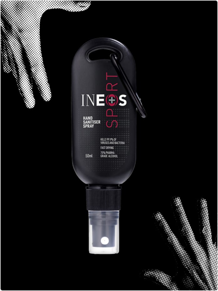 a photo of a travel-sized ineos hygienics sports hand sanitiser spray on a black background with hands reaching for it