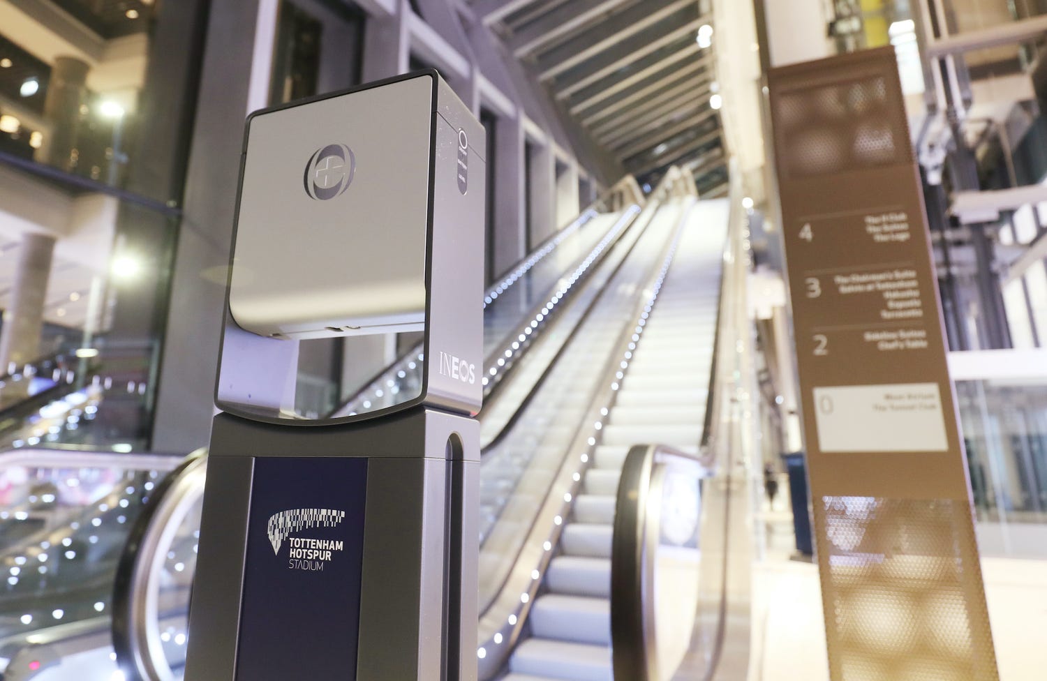 a photo of an ineos hygienics dispenser in front of an escalator
