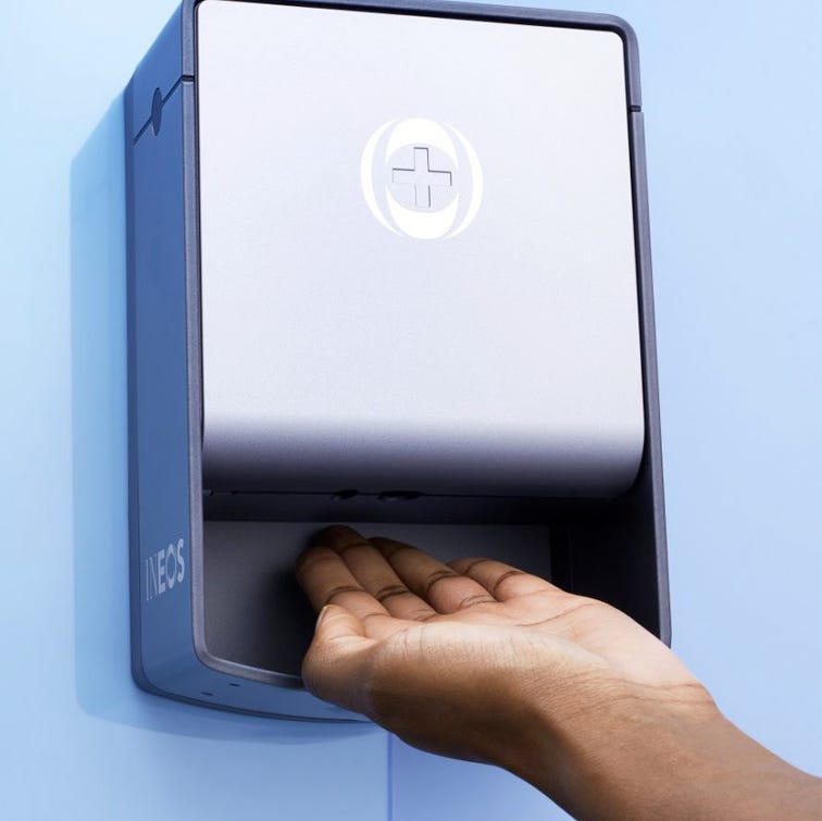 a photo of someone using a wall mounted ineos hygienics hand sanitiser dispenser