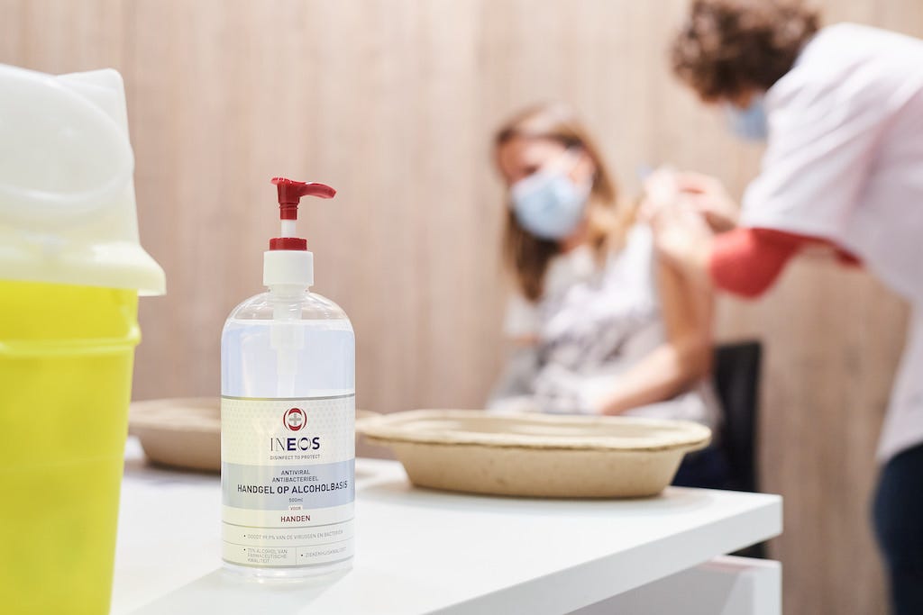 a photo of a bottle of ineos hygienics hand sanitiser in a vaccination clinic