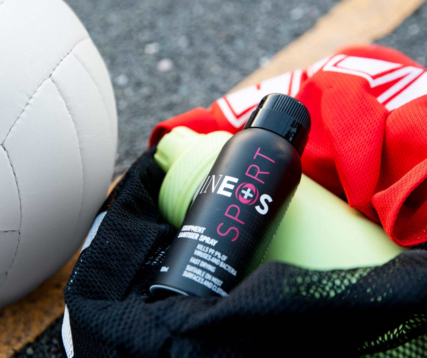 a photo of ineos hygienics sanitiser spray in a kit bag with a netball next to it