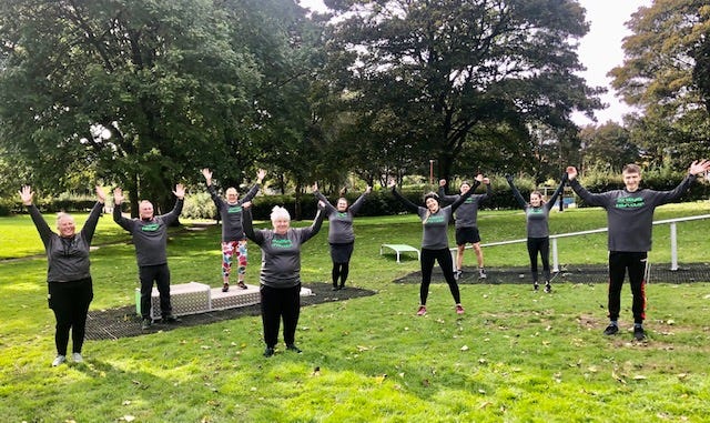 a group of people exercising in a park