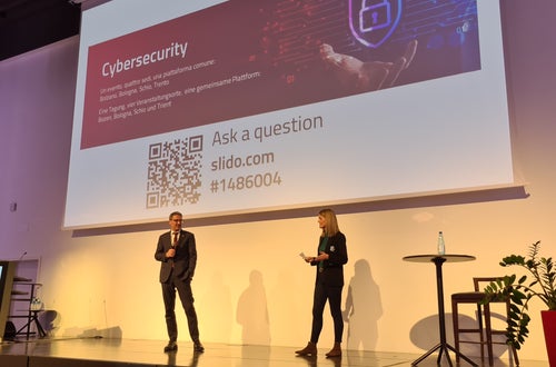 LH Arno Kompatscher auf der Bühne in Bozen mit Moderatorin Claudia Messner. Foto: Siag, 2022 LH Arno Kompatscher auf der Bühne in Bozen mit Moderatorin Claudia Messner. Foto: Siag, 2022