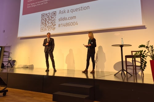LH Arno Kompatscher auf der Bühne in Bozen mit Moderatorin Claudia Messner. Foto: Siag, 2022 LH Arno Kompatscher auf der Bühne in Bozen mit Moderatorin Claudia Messner. Foto: Siag, 2022