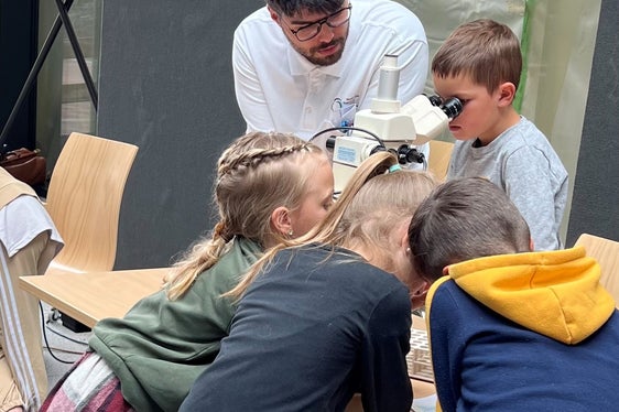Dr. Raphael Pinti erklärt den Kindern das Mikroskop
