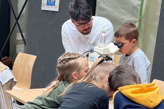 Dr. Raphael Pinti erklärt den Kindern das Mikroskop