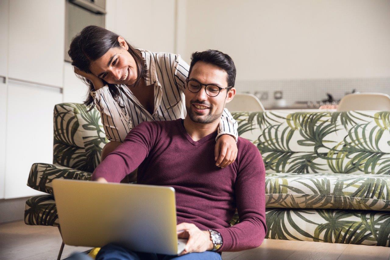 Couple looking for homes on their laptop