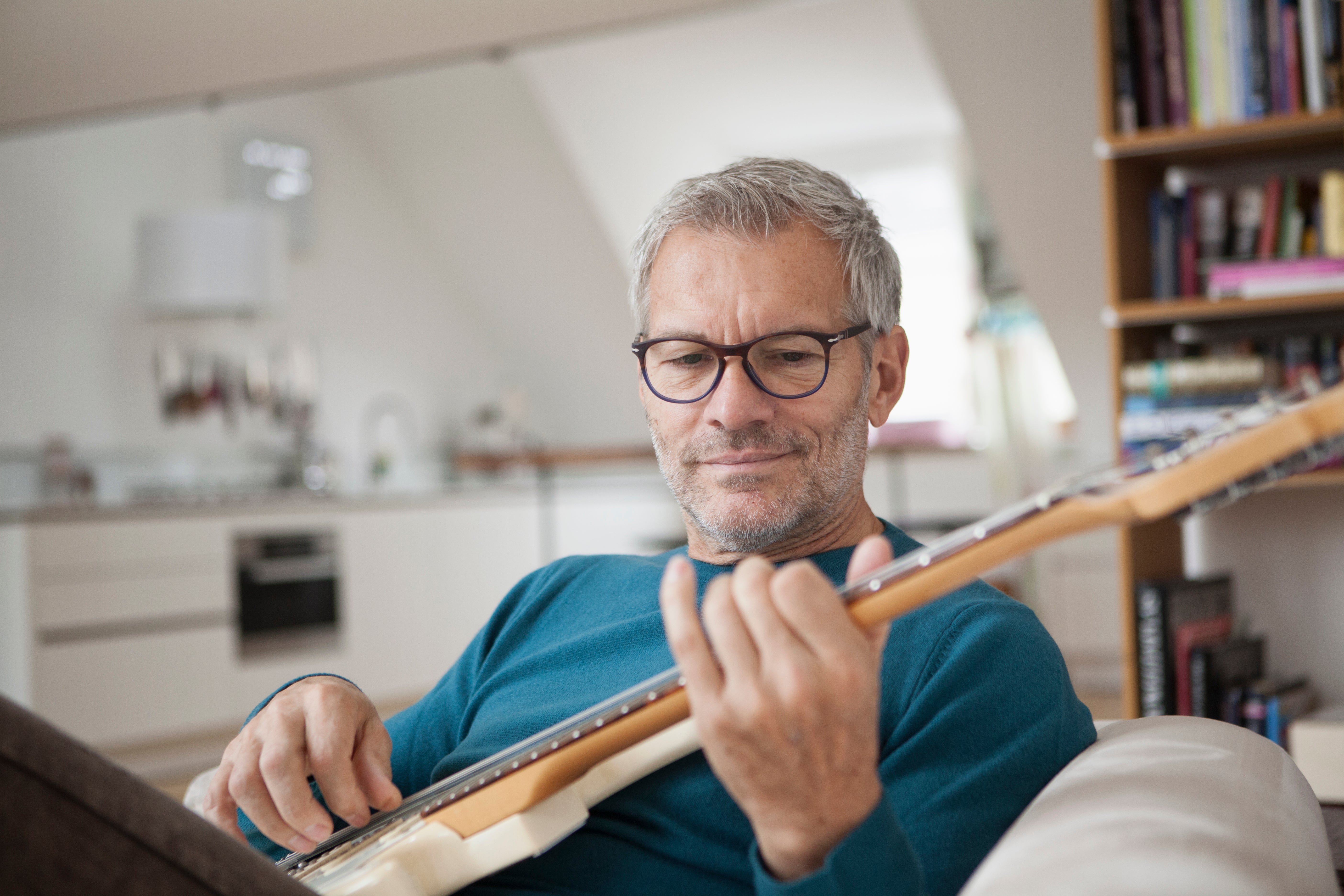 Man playing guitar in home