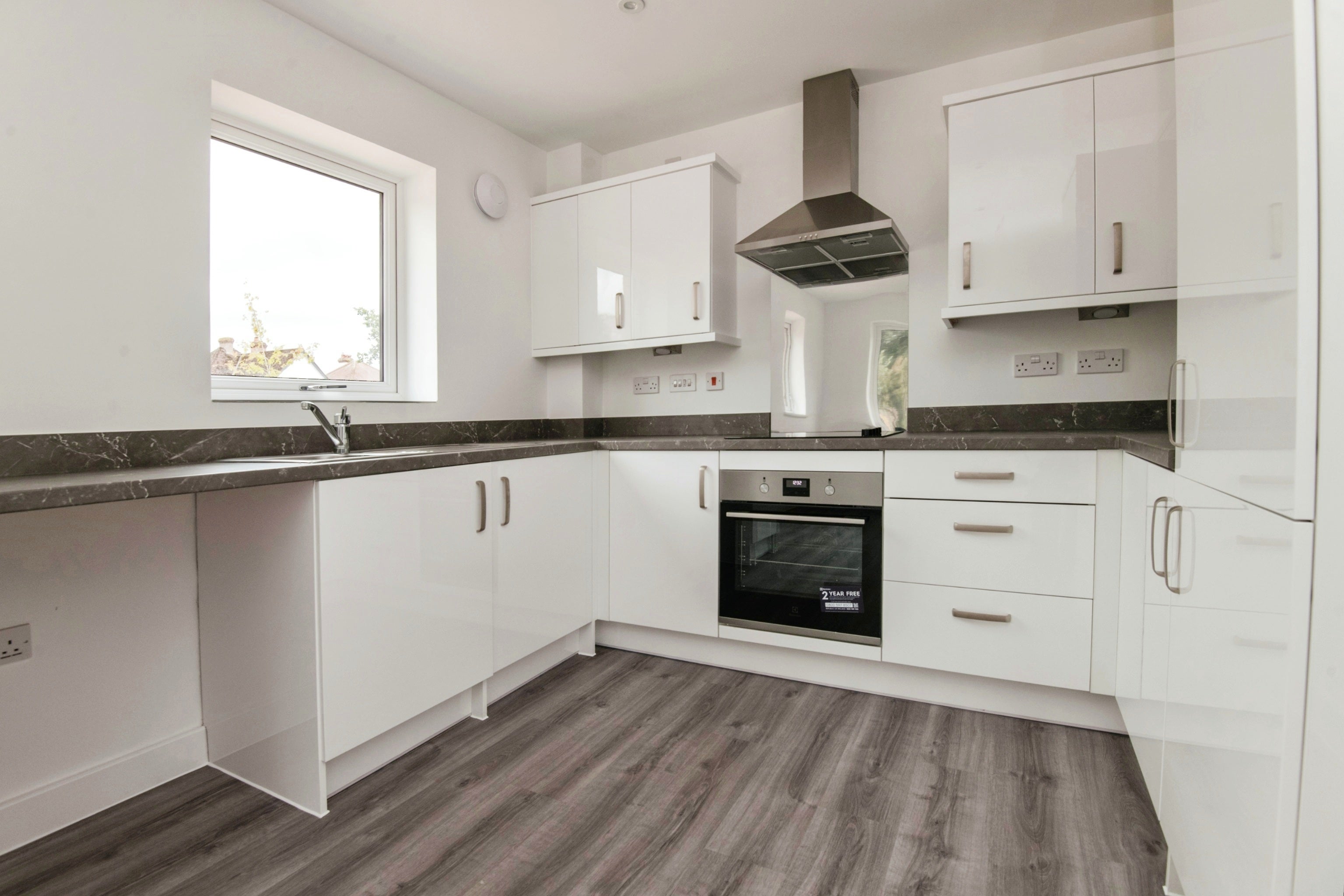 Grey and white kitchen, with oven, cooker and window