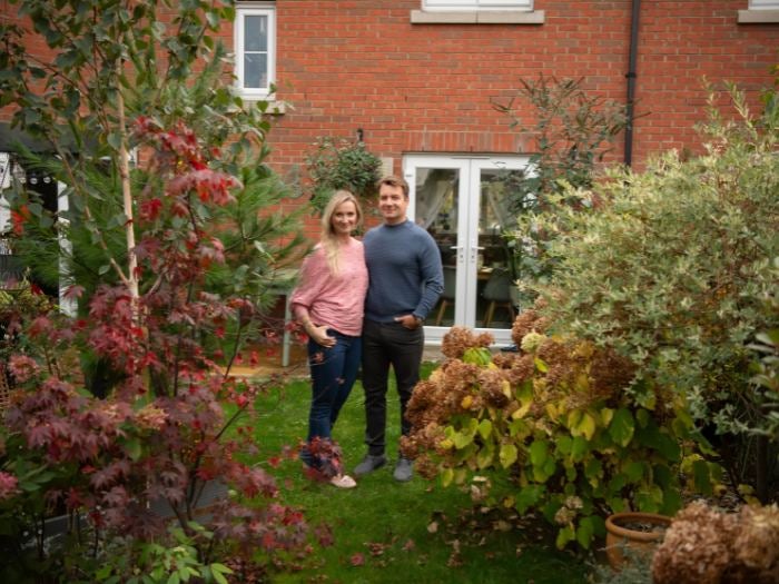 Ewa and Aleks pose for a photo in their garden