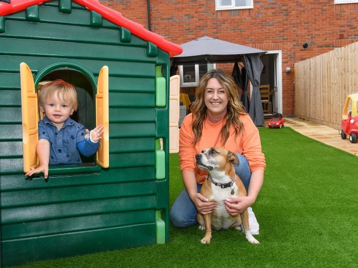 Vicki, her son, and their dog pose for a picture in the garden