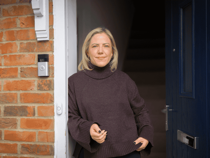 Lucy stands in the doorway to her new home whilst holding her keys