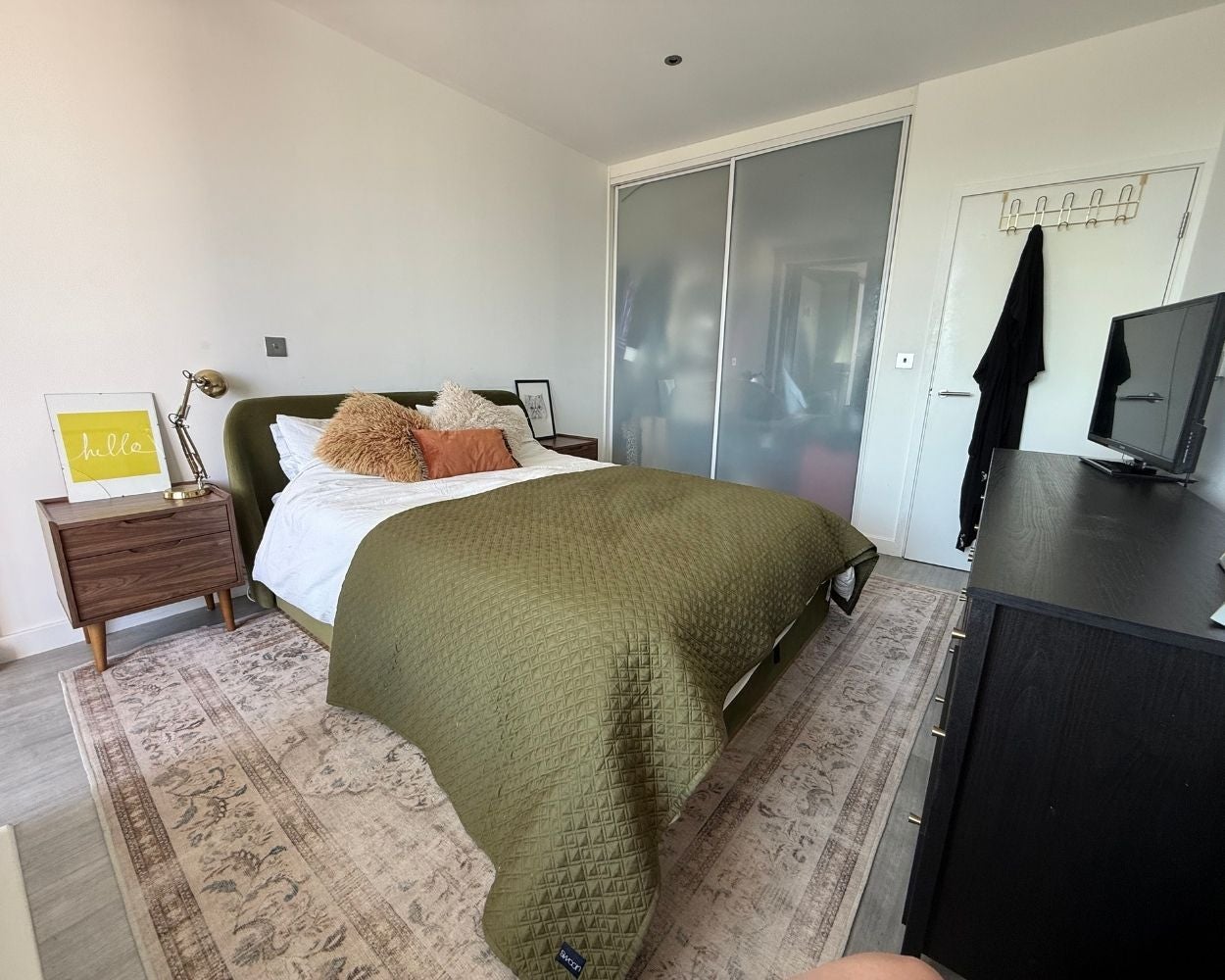 Photo of the bedroom showing the double bed, two bedside tables and built-in wardrobes