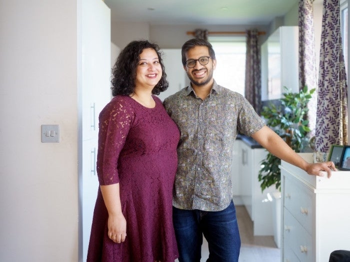 Anindya & Oishani pose for a picture standing in their living room.